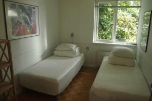 twee bedden in een kamer met twee ramen bij The House At The Mountain in Lemvig
