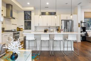 a kitchen with a large island with bar stools at Chic, Modern Silver Lake Oasis with Rooftop Panoramic DTLA Views & Private Garage in Los Angeles