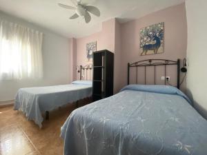 1 Schlafzimmer mit 2 Betten und einem Deckenventilator in der Unterkunft Apartamento Rosa in Arroyo Frio