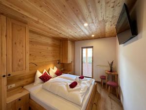 ein Schlafzimmer mit einem großen Bett in einem Holzzimmer in der Unterkunft Hotel ŠURC in Kranjska Gora