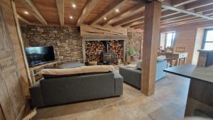 - un salon avec un canapé et une cheminée dans l'établissement La ferme de Jouane, à Besse-et-Saint-Anastaise