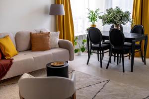 sala de estar con sofá y mesa con sillas en AA Apartament, en Varsovia