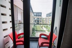 dwa czerwone krzesła siedzące przed oknem w obiekcie Ghana luxury Apartments w Akrze