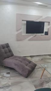ein Sofa im Wohnzimmer mit einem Flachbild-TV in der Unterkunft bel appartement de vacances in Saidia 