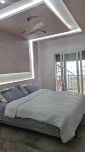 ein Schlafzimmer mit einem Bett mit einer Decke mit Vögeln darauf in der Unterkunft bel appartement de vacances in Saidia 