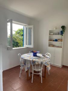a dining room with a table with chairs and a window at Villa Paso in Ustica