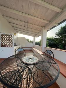 a patio with a table and chairs on a porch at Villa Paso in Ustica