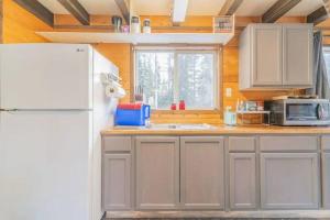 uma cozinha com um frigorífico branco e um lavatório em A Cabin You Won't Want to Leave em Fairbanks