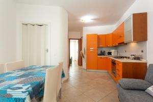uma cozinha e sala de estar com uma cama e um sofá em Scialài em Marina di Ragusa