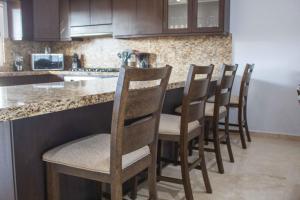 una cucina con fila di sedie al bar di Private Villa 115 in Gated Community Pet-friendly a Cabo San Lucas