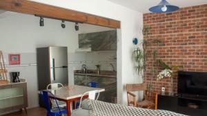 a kitchen with a table and a refrigerator at Apto aconchegante e familiar em BC in Balneário Camboriú