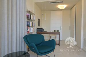 sala de estar con silla azul y mesa en Relais Ulivo Ariana, en Gaeta