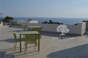 una mesa y sillas en un patio cerca del océano en Relais Ulivo Ariana, en Gaeta