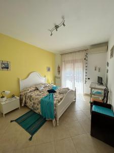 una camera con un letto in una stanza con pareti gialle di La Dimora di Livia a Lido di Ostia