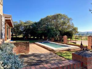 a swimming pool in a yard next to a house at Mission House in Howick