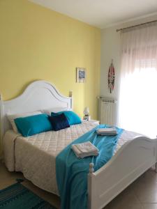 una camera da letto con un grande letto con cuscini blu di La Dimora di Livia a Lido di Ostia