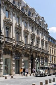 un edificio con un coche aparcado delante de él en The Originals Boutique, Hôtel Danieli, Avignon en Aviñón