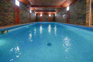a large swimming pool with blue water in a building at Dom Wczasowy Jędrol in Poronin