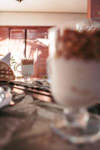 una mesa con un vaso de leche y una taza de café en Pousada Brigitte, en Barra do Sahy