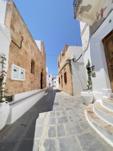een steegje in een oude stad met witte gebouwen bij Villa AleNi Lindos in Lindos