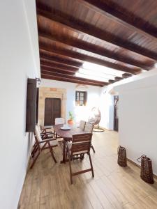 een woonkamer met een houten tafel en stoelen bij Villa AleNi Lindos in Lindos
