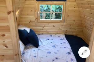 a bed in a log cabin with a window at Pen y Buarth Pod - Caravan Site in Caernarfon