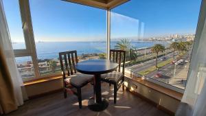 1 mesa y 2 sillas en una habitación con vistas al océano en Hotel Diego de Almagro Valparaíso, en Valparaíso