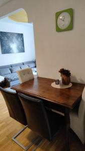 une table dans une pièce avec une horloge sur le mur dans l'établissement Lalina, à Liezen