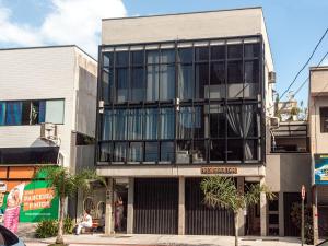 a building with large windows on a city street at Residencial Aroeira in Balneário Camboriú