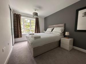 um quarto com uma cama grande e uma janela em Luxury Apartments - Wallis Square, Farnborough em Farnborough