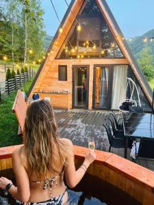 a woman in a swimming pool with a glass of wine at Harmony Villa Lupeni Straja in Lupeni