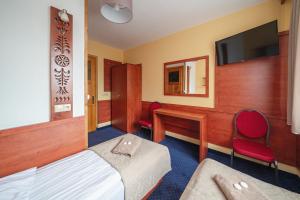 Pokój hotelowy z łóżkiem, biurkiem i telewizorem w obiekcie Dom Wczasowy Jędrol w Poroninie