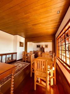 una sala da pranzo con tavoli e sedie in legno di Pousada Hortelã Village a Campos do Jordão