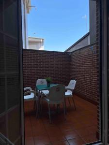a patio with tables and chairs and a brick wall at Apartamento junto al parque in Ponferrada
