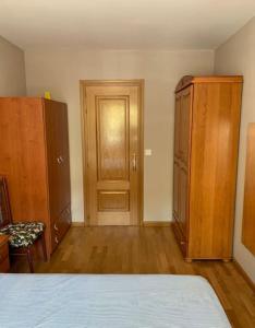 a bedroom with a bed and a cabinet and a door at Apartamento junto al parque in Ponferrada