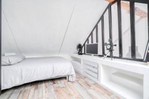 een witte slaapkamer met een bed en een raam bij Le Soft Indus - Duplex avec parking et balcon proche Aéroport Paris CDG in Montfermeil