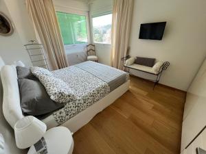 una camera con letto, TV e sedia di Casa Amina a Genova
