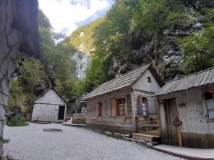 a group of wooden buildings on a gravel road at Brunarica Jeršin in Cerkno