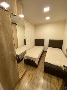 Cette chambre comprend 2 lits et un miroir. dans l'établissement My Guesthome, à Erevan