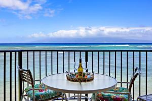 a table and chairs on a balcony overlooking the ocean at Kahana Reef 318 in Kahana