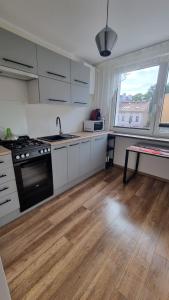 a kitchen with white cabinets and a black stove at Mieszkanie Grunwaldzka in Olsztyn
