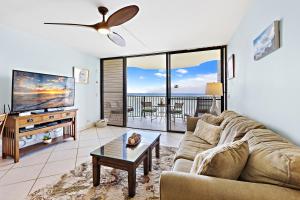 a living room with a couch and a flat screen tv at Kahana Reef 318 in Kahana +21 photos
