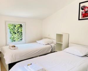 two beds in a room with a window at Maison de vacances proche du centre de Saint Raphael in Saint-Raphaël