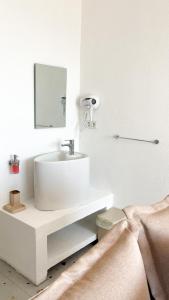 ein weißes Badezimmer mit einem Waschbecken und einem Spiegel in der Unterkunft Thanos Hotel in Muğla