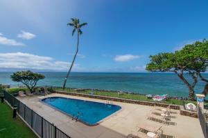 una piscina con l'oceano sullo sfondo di Kahana Reef 208 a Kahana