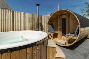 uma grande banheira de madeira ao lado de uma cerca de madeira em SpaHuset em Sommelsdijk