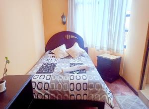 a bedroom with a bed with a table and a window at HOSTAL MAYA INN in La Paz