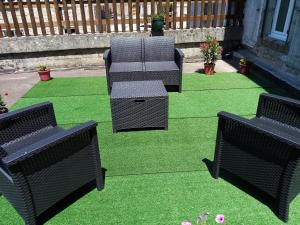 four chairs on a lawn with green grass at Appart' Argences en Aubrac in Sainte-Geneviève-sur-Argence