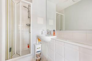 bagno bianco con lavandino e doccia di Brands Hatch Apartment a Darenth