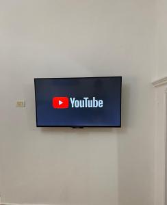 een televisie met een youtube bord op een muur bij Marl's Home in Berat